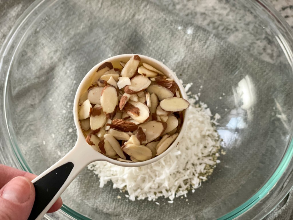 adding sliced almonds to a bowl
