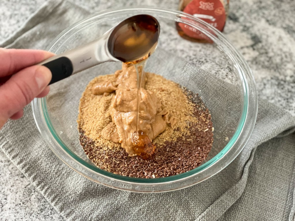 adding keto syrup to a mixing bowl