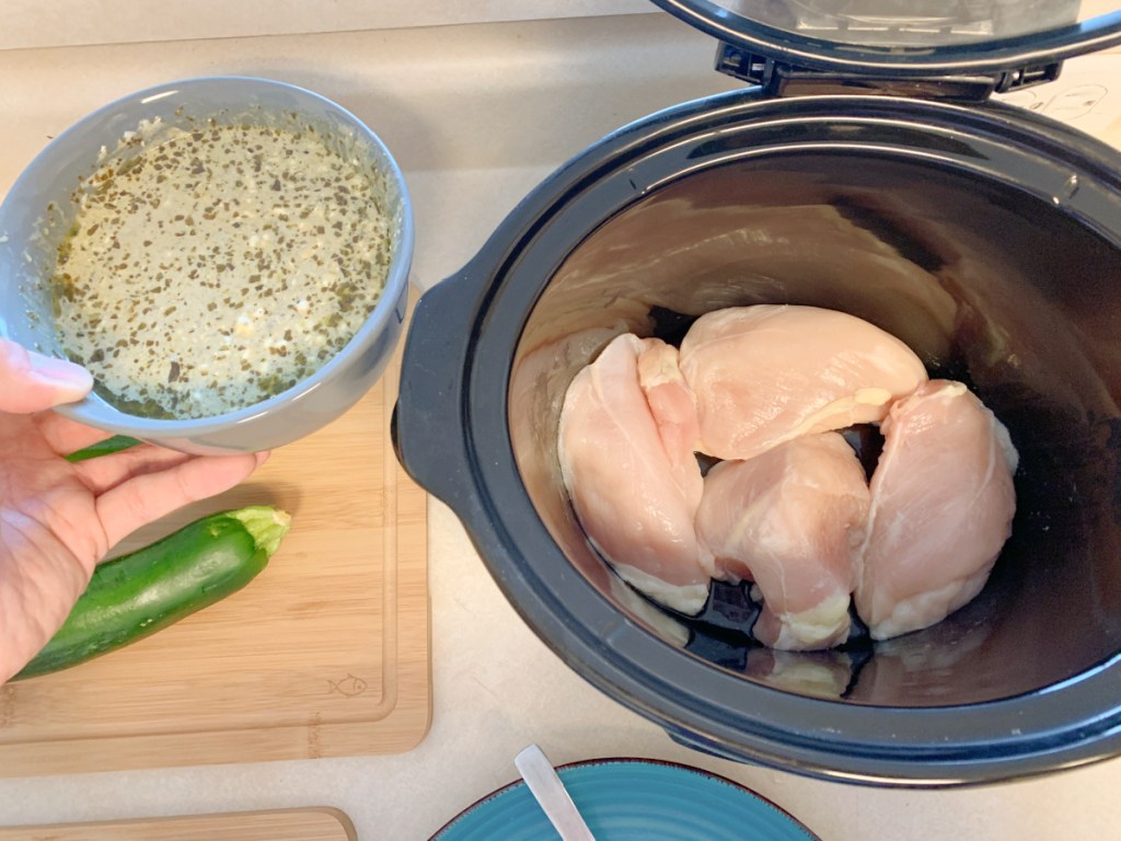 lemon pesto chicken adding sauce to slow cooker 