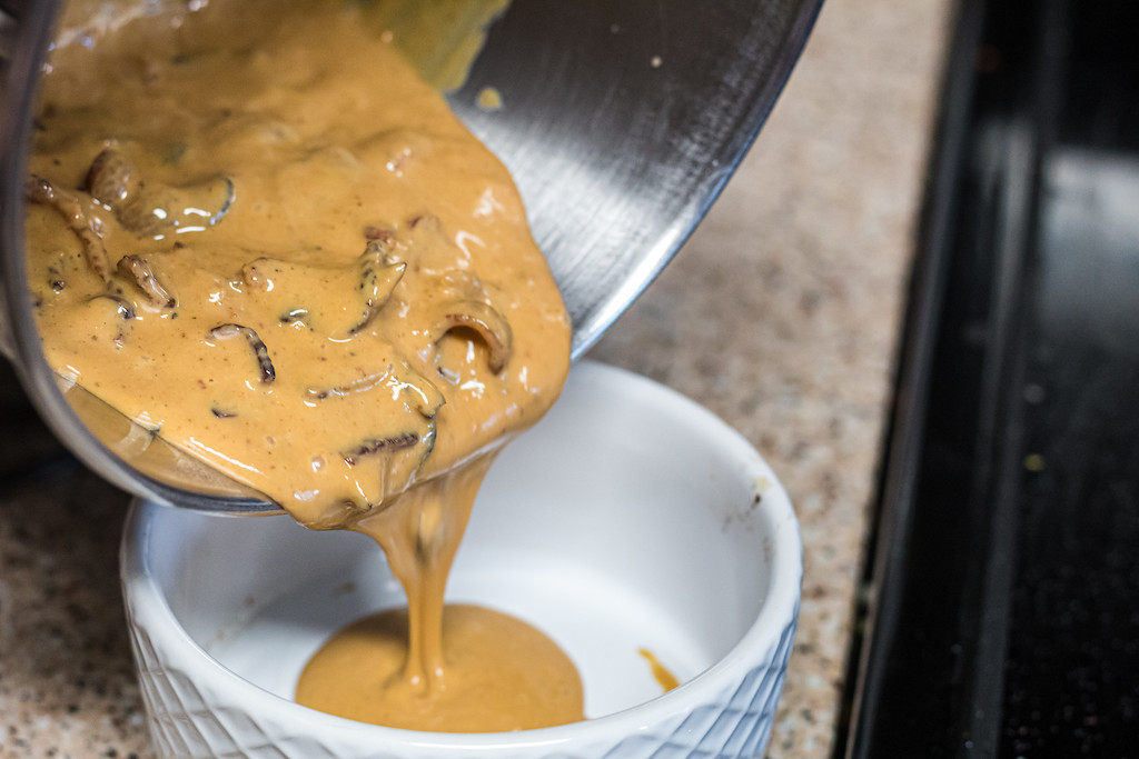 pouring peanut butter bacon sauce into bowl 