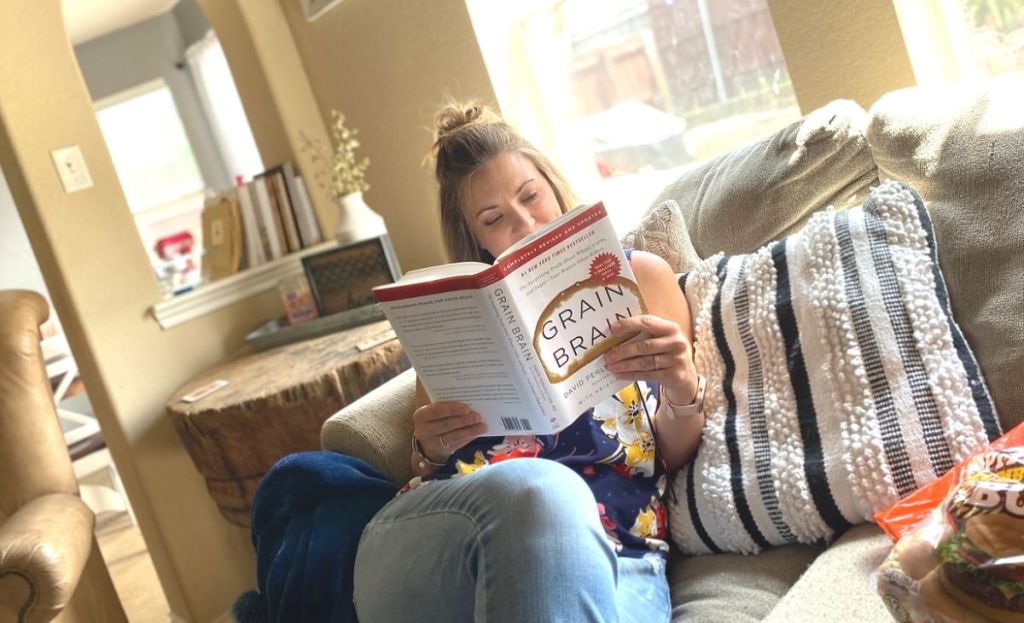 A woman reading a book on the couch