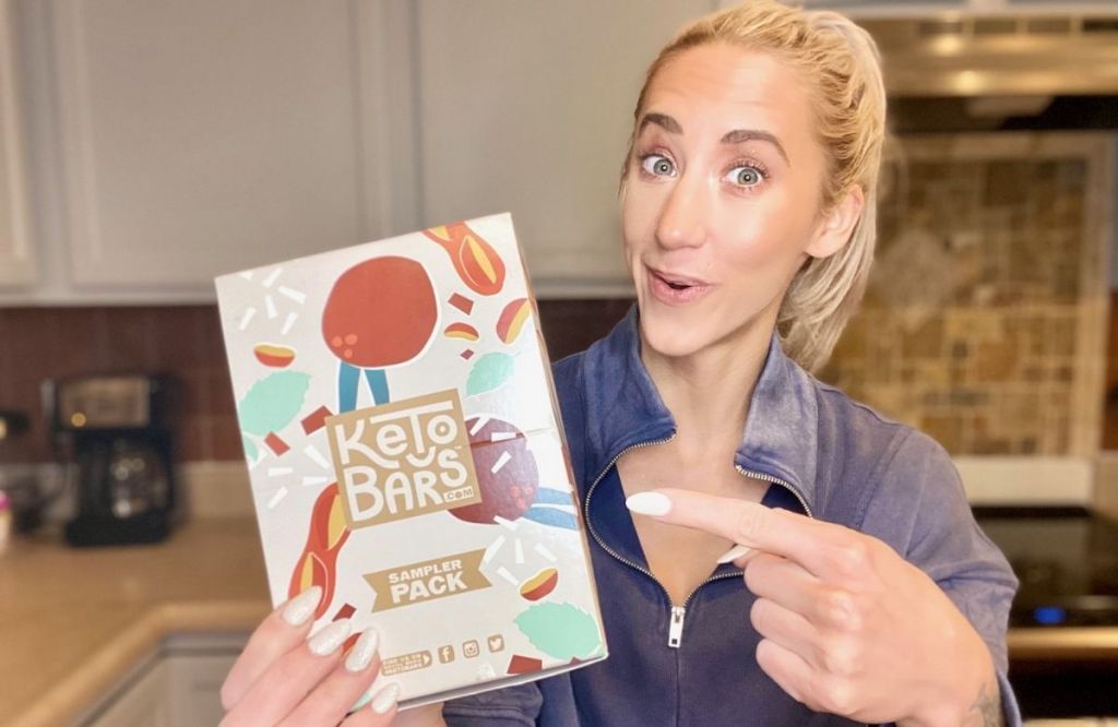 A woman holding a box of keto bars