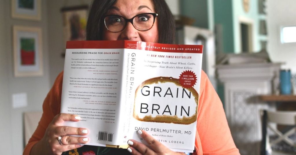 A woman holding a book in front of her face