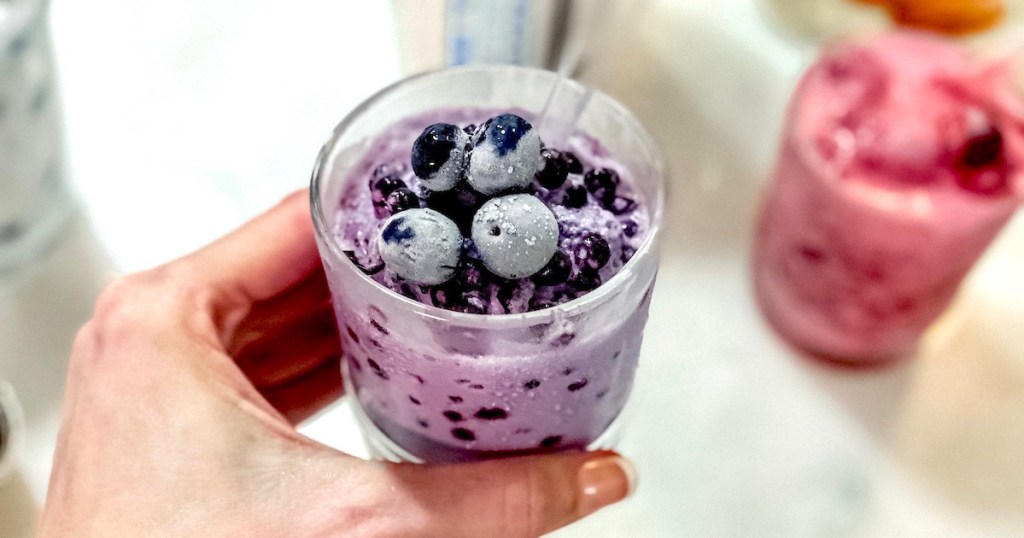 hand holding a cup of blueberries 