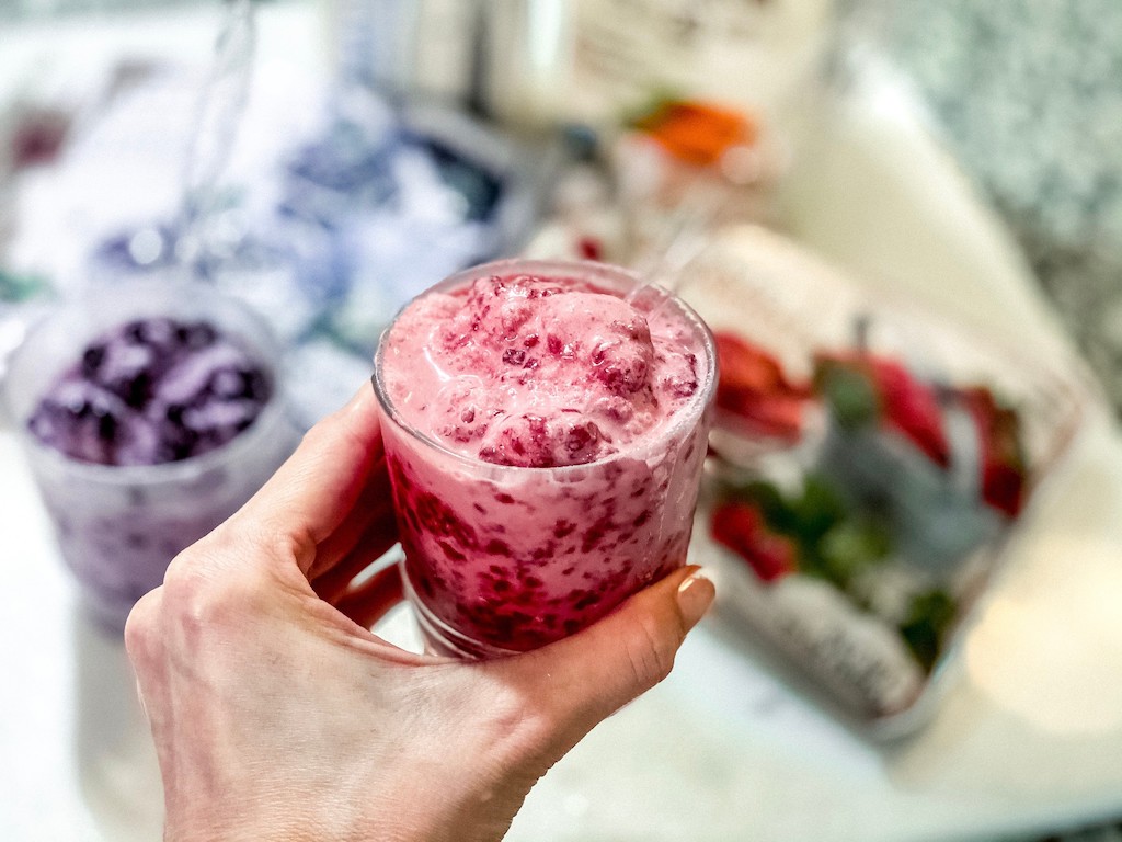 holding cup of berry keto ice cream
