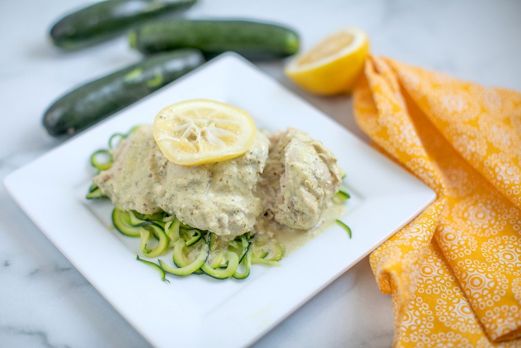 lemon pesto chicken on white plate with zoodles 