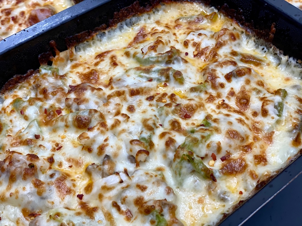 close up of Marco's pizza bowl with cheese and green peppers 