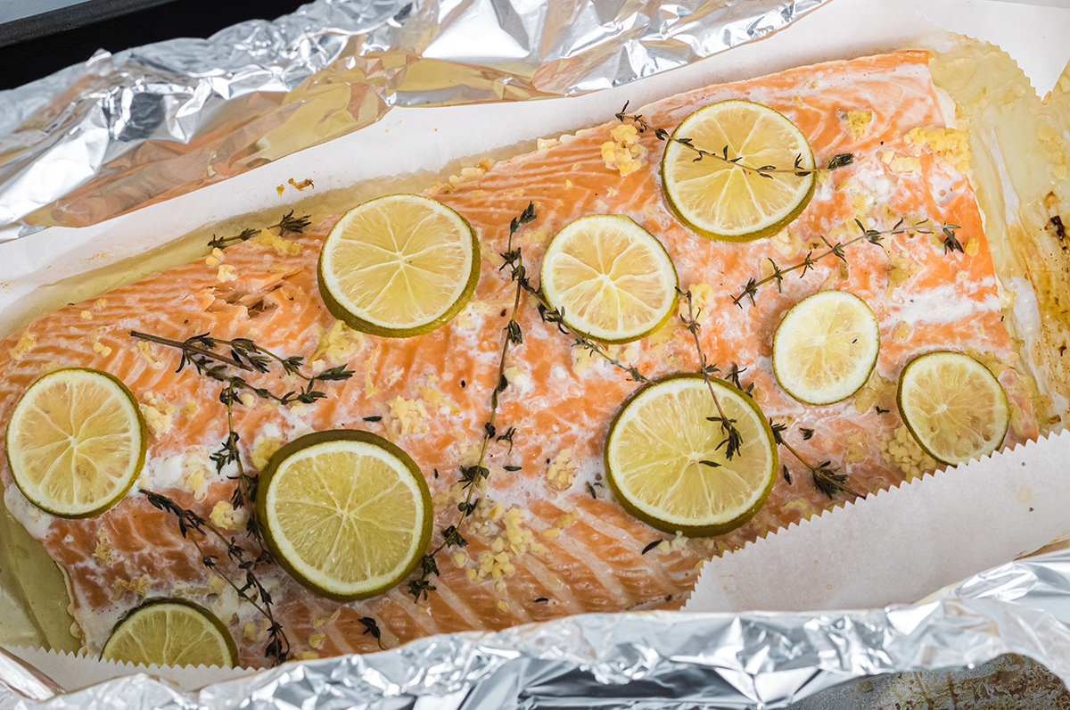 large piece of salmon with citrus and fresh herbs