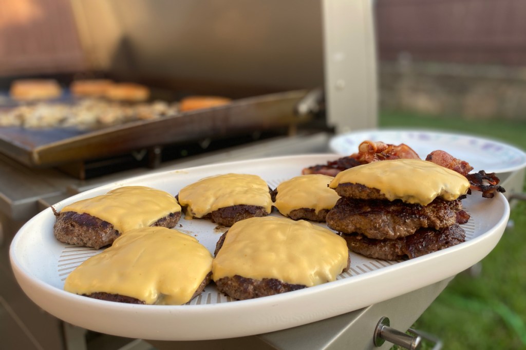 burgers on a plate next to grill