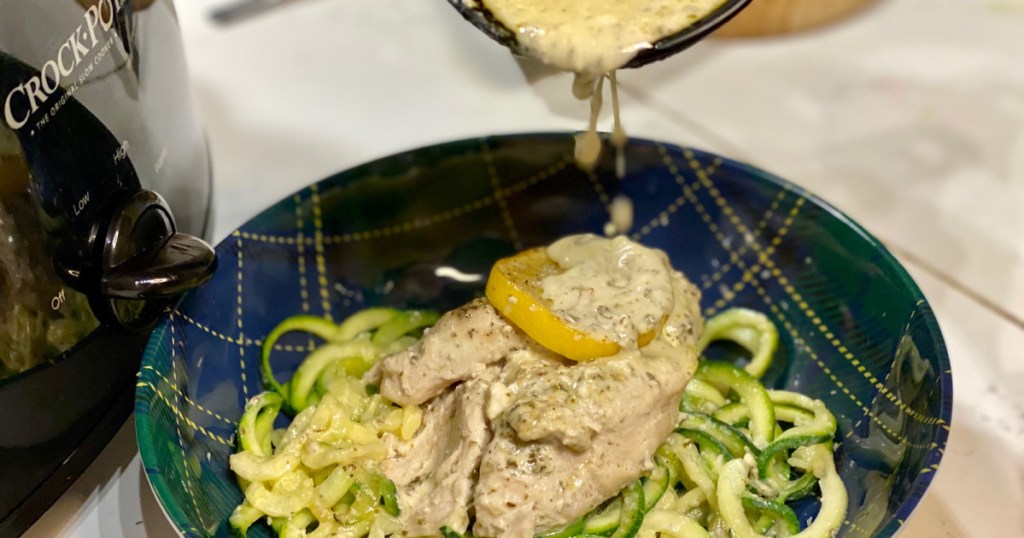 putting lemon pesto sauce on chicken 