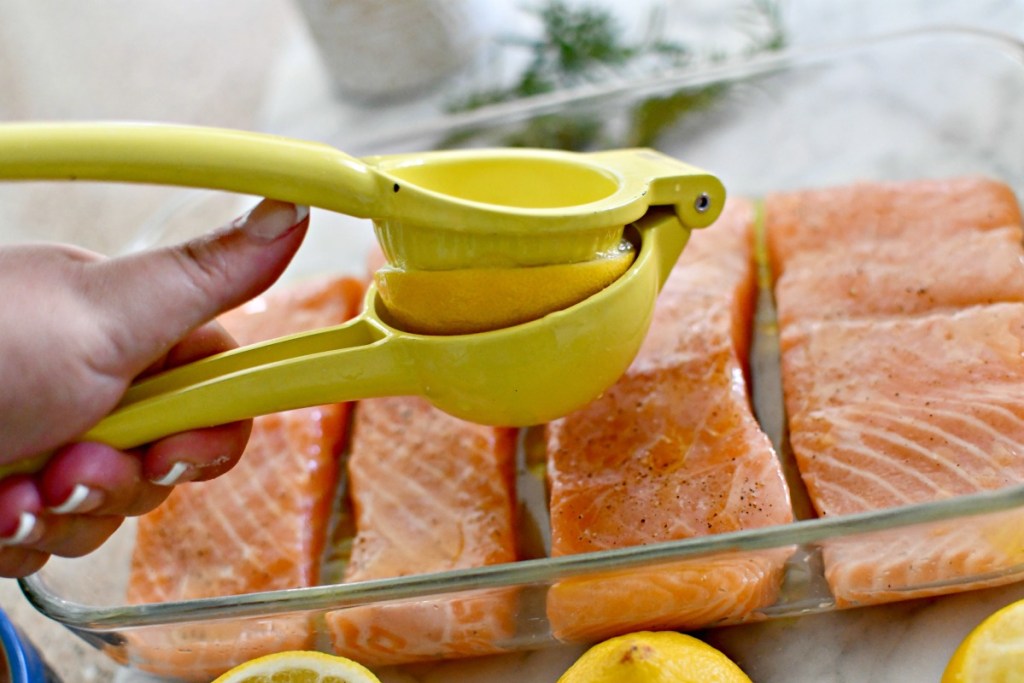 using a citrus juice to squeeze lemon juice on salmon