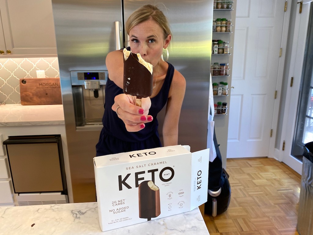 woman holding keto ice cream bar in kitchen 