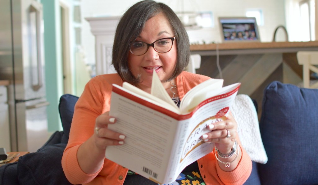 woman reading grain brain book sitting on couch