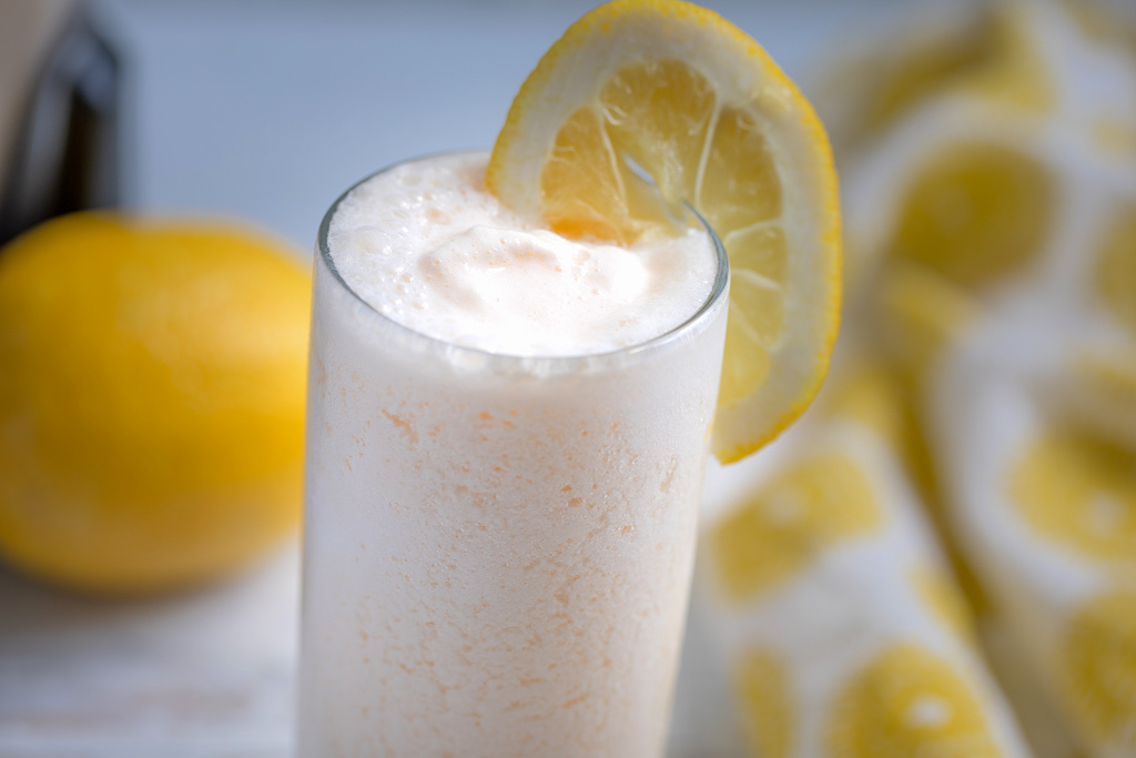 frosted lemonade with lemon wedge on glass