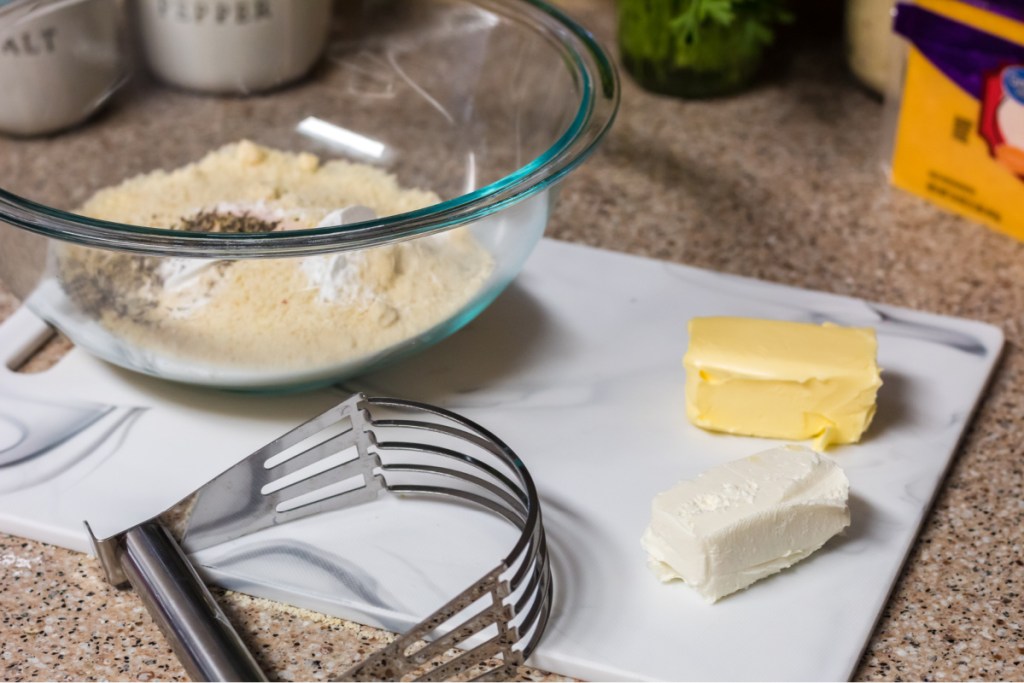 cutting butter and cream cheese in a bowl