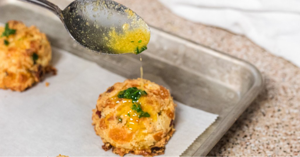putting melted butter on keto loaded biscuits