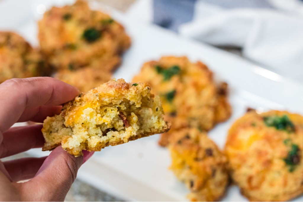 girl holding a loaded keto cheddar and bacon biscuit