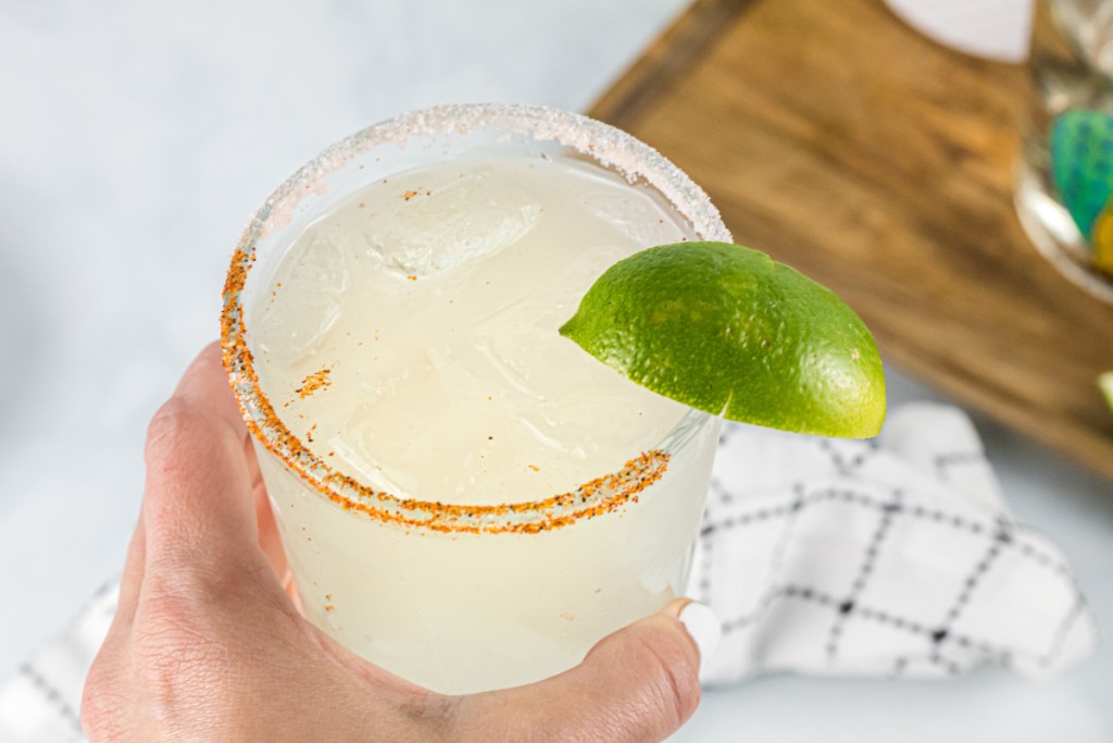 holding a low carb and sugar free margarita with chili salt rim