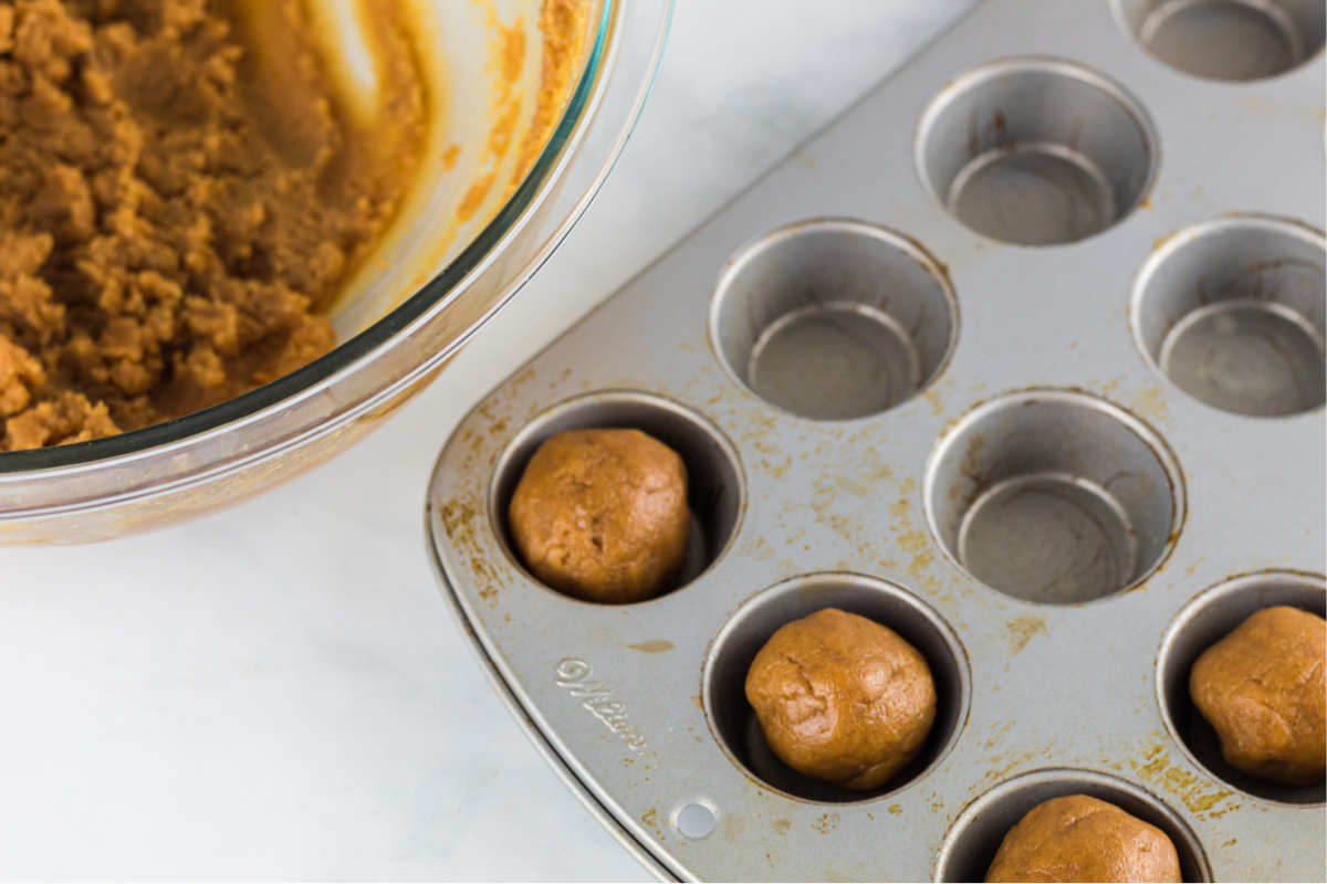 rolling dough into balls and placing in muffin tin