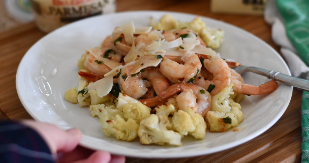 hand holding a plate of keto shrimp scampi which is part of an easy keto meal plan