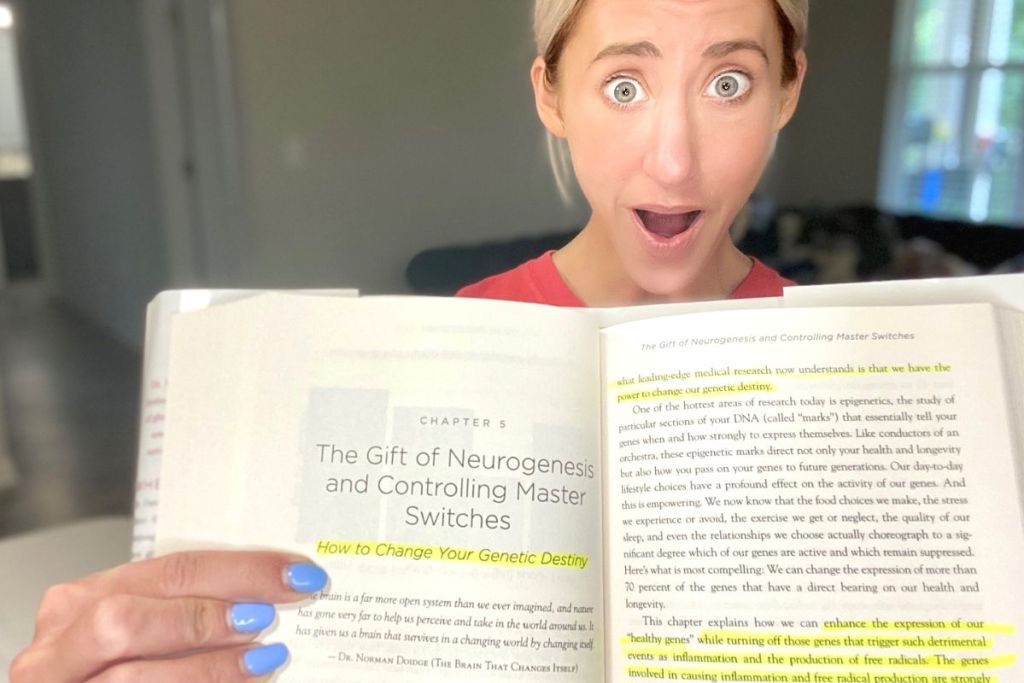 A woman holding the Grain Brain book and pointing to highlighted text 