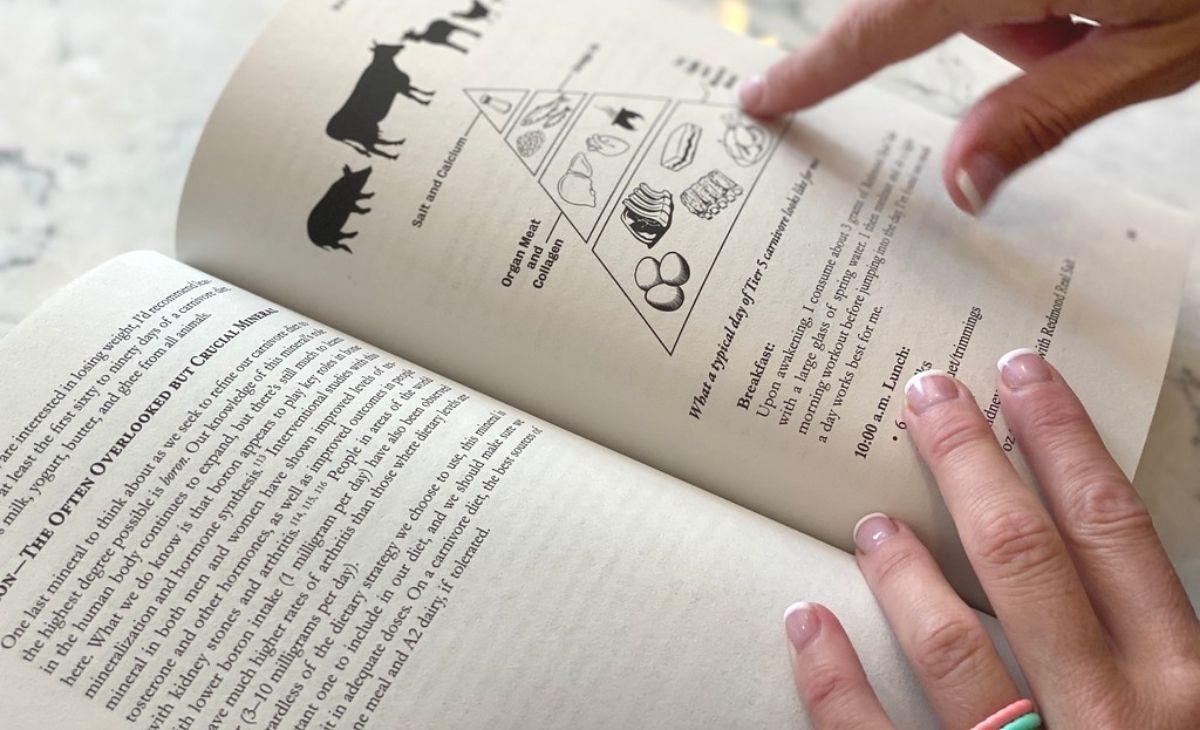 A hand pointing to a graph in a book