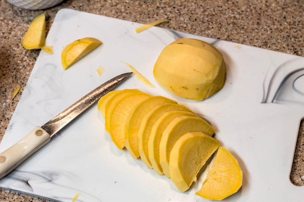 slicing up rutabaga on cutting board 