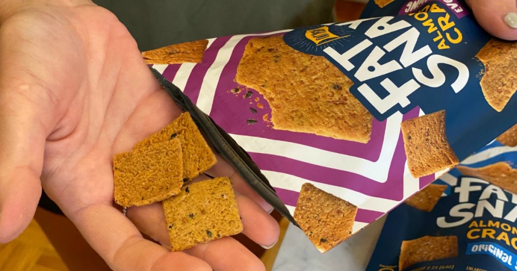 putting Fat Snax keto crackers in hand 