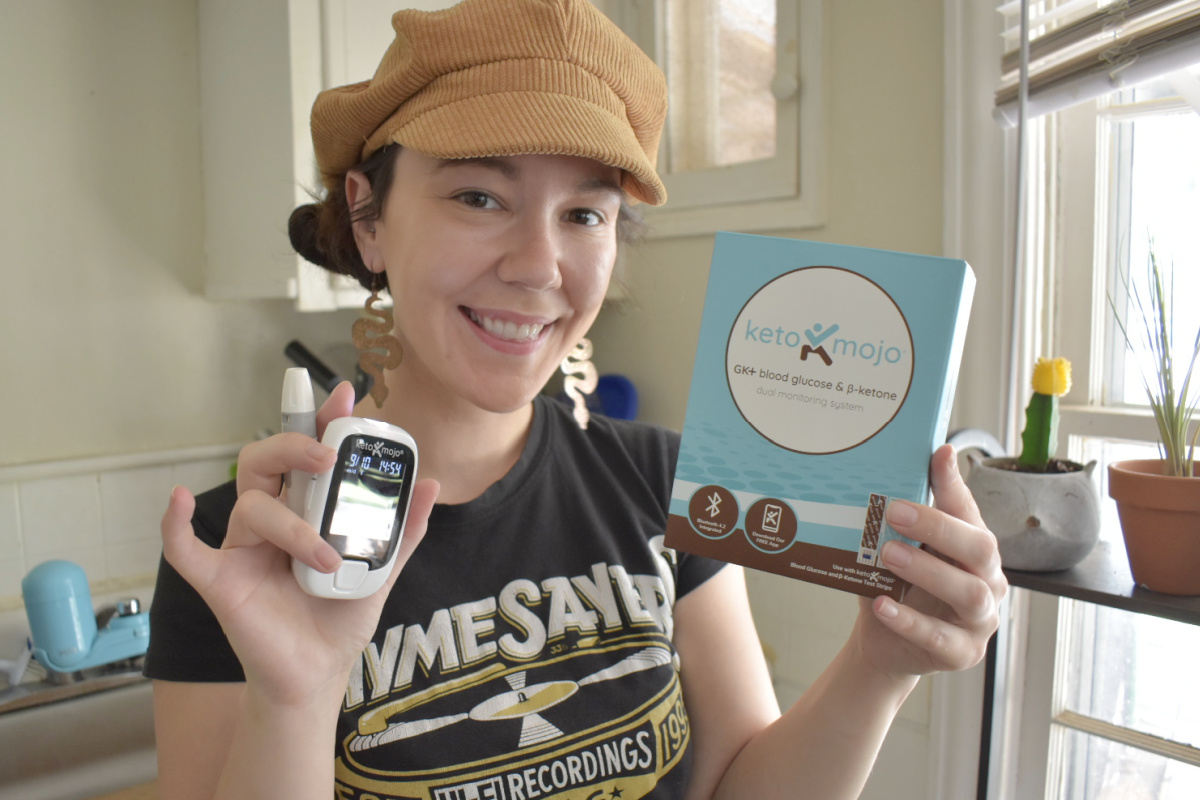 woman holding keto mojo case and monitor