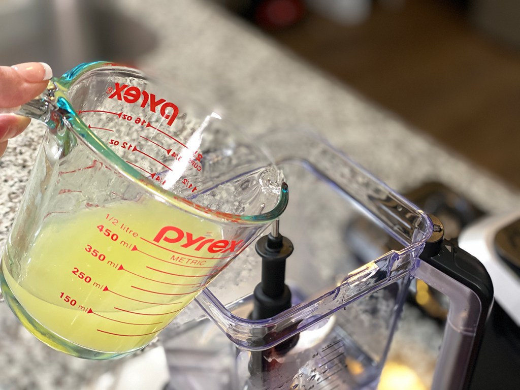 pouring lemon juice into a blender