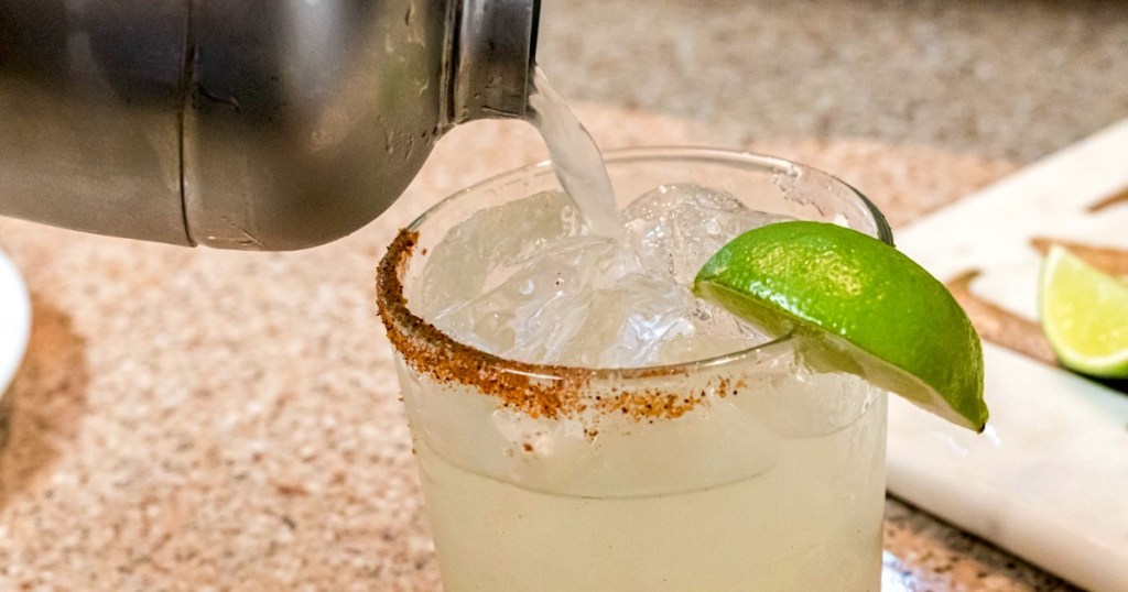 pouring a keto margarita into a glass