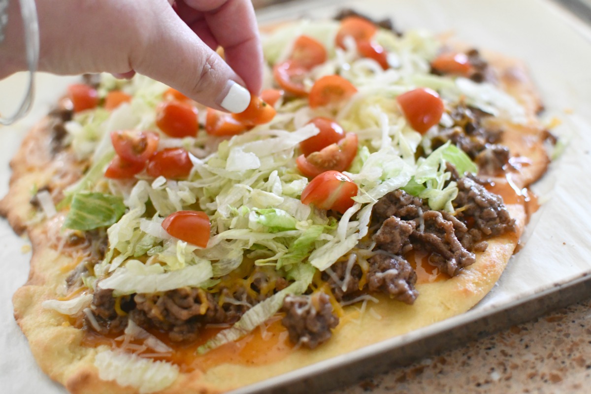 putting toppings on keto taco pizza
