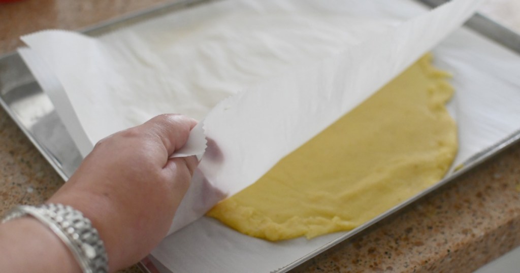 rolling out fathead dough between parchment paper