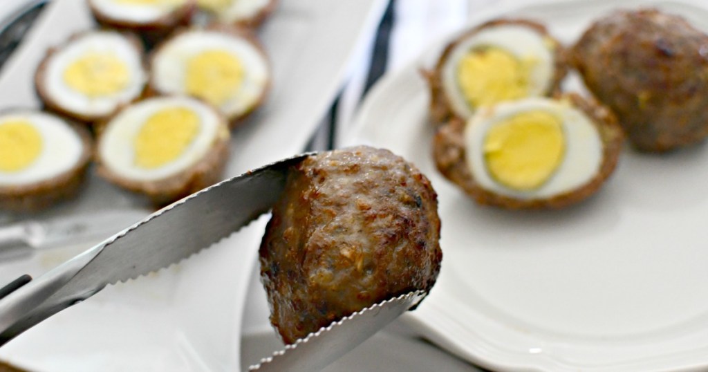 holding a Scotch egg with kitchen tongs 
