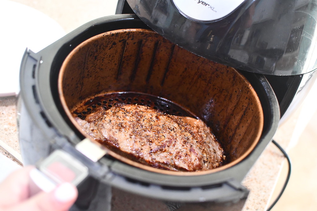 pulling steak out of the air fryer 