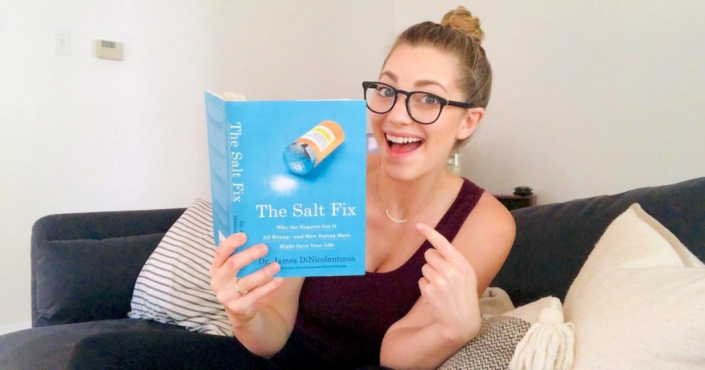 woman holding the salt fix book pointing to front cover smiling