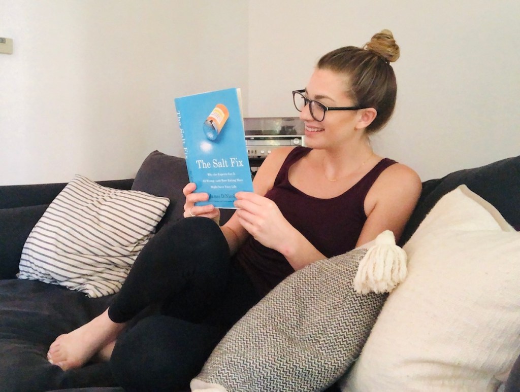 woman sitting on couch reading the salt fix book