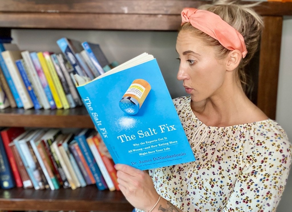 woman reading the salt fix book in front of book shelves