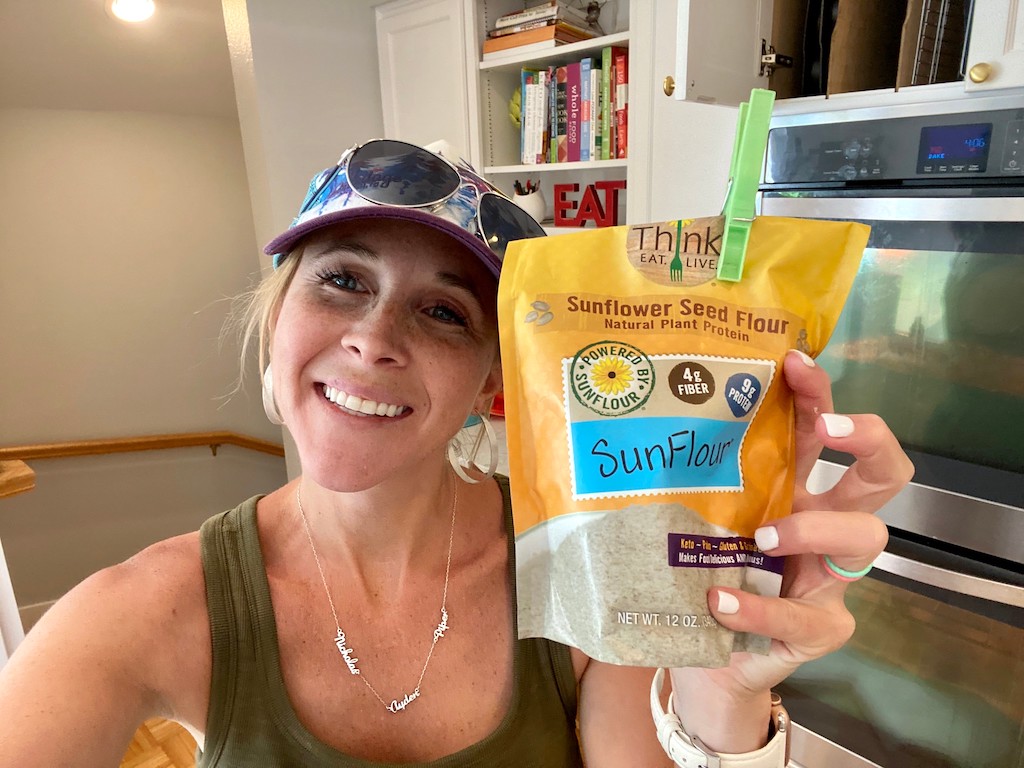 woman holding Think Eat Live sunflower seed flour