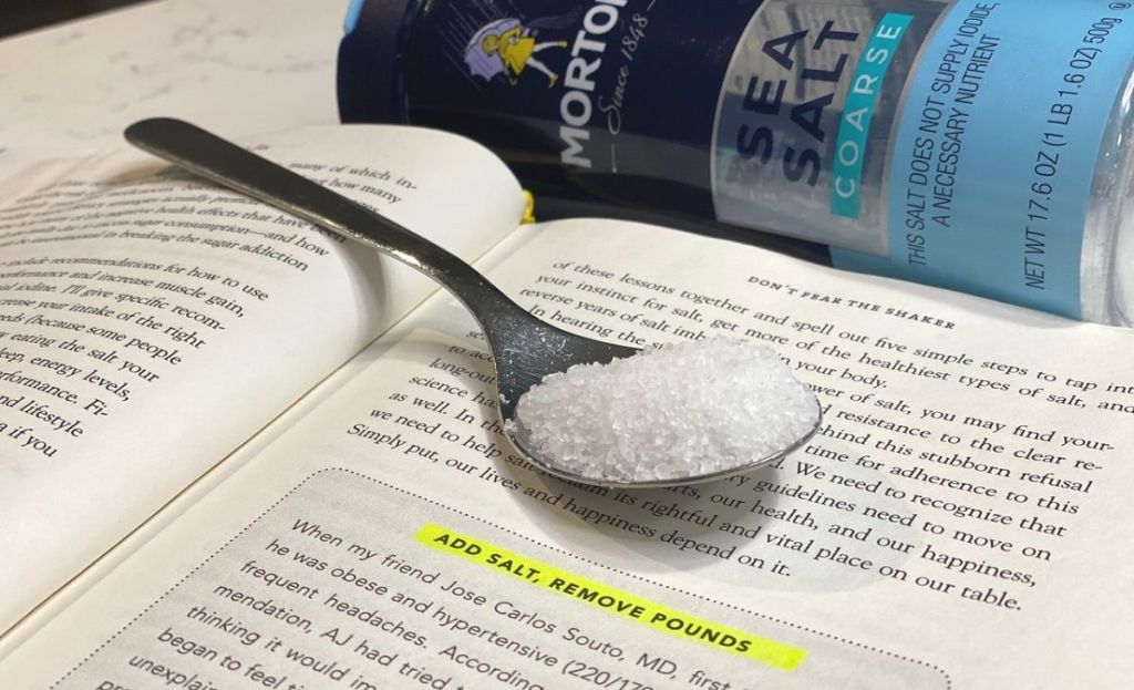 A spoonful of salt sitting on a book page