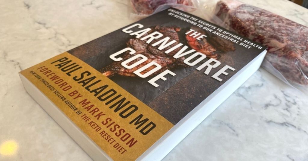 A book on a counter next to some steaks