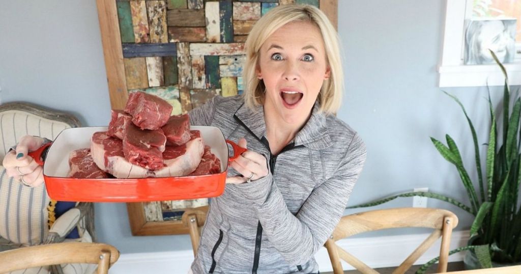 A woman holding a dish full of ribeye steak