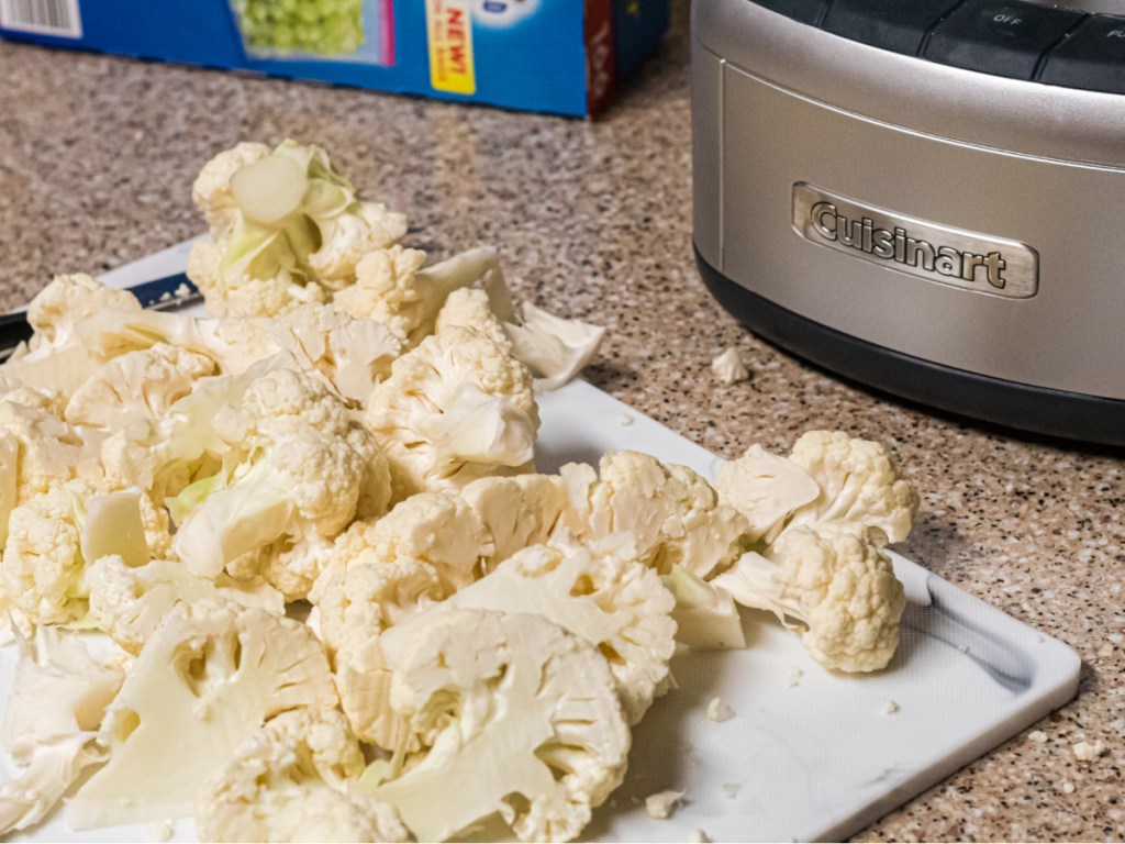 cauliflower cut up on cutting board