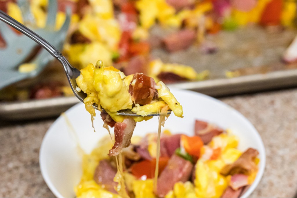 taking bite of keto scrambled eggs and sausage 