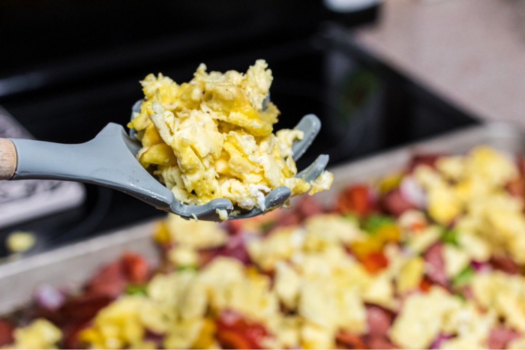 adding scrambled eggs to sheet pan breakfast