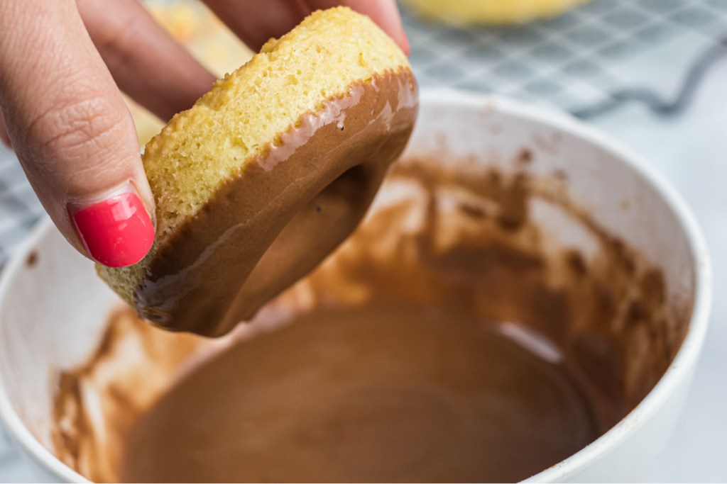 dipping keto donut into chocolate icing