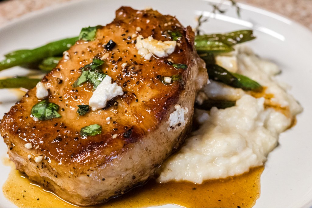 plate of mashed cauliflower, green beans, and pork chops