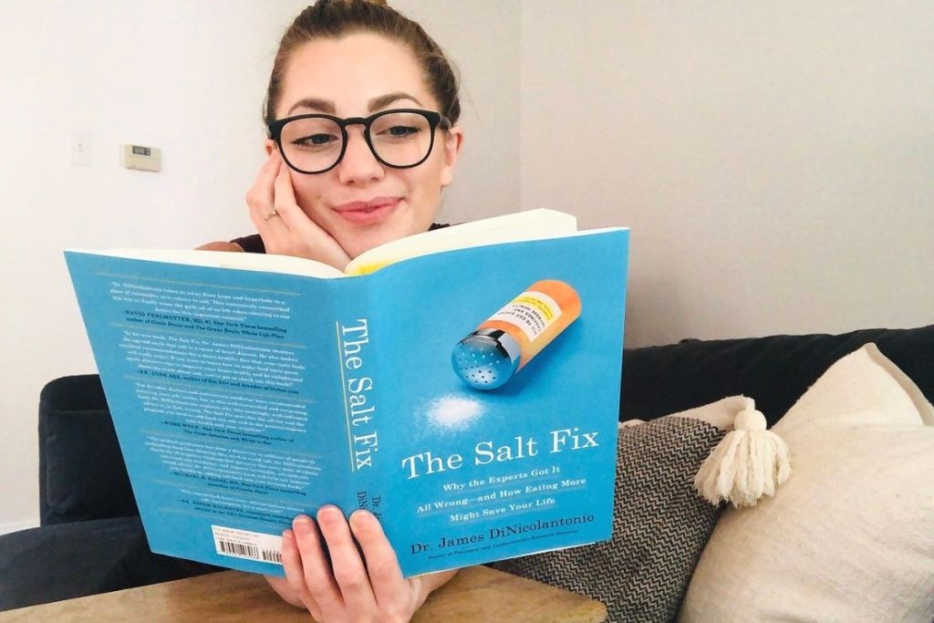 A woman sitting on a couch reading a book