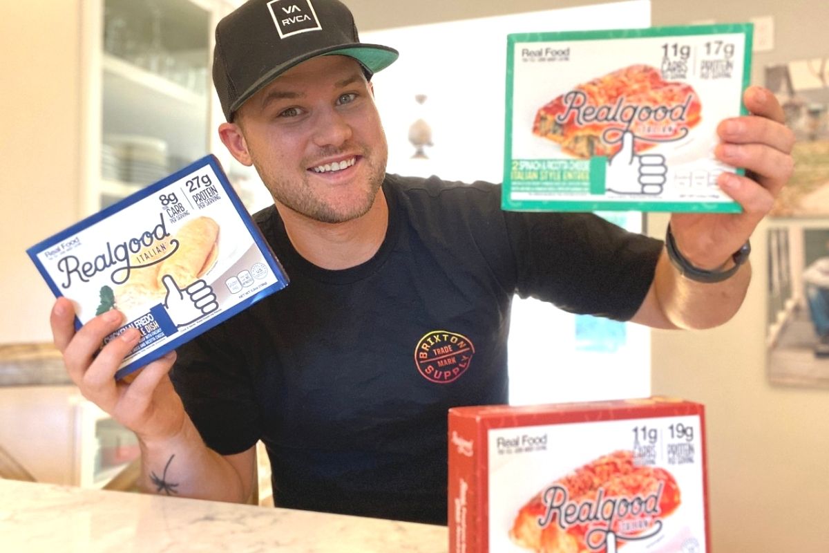 A man holding two boxes of Real good foods enchilada meals