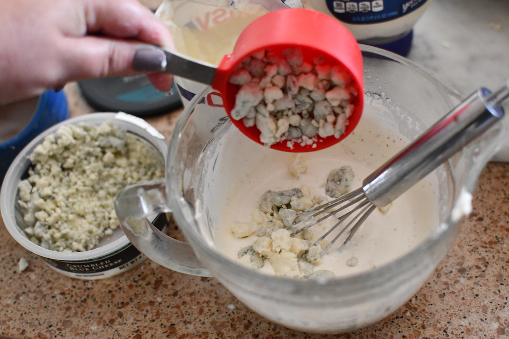 adding blue cheese to homemade salad dressing